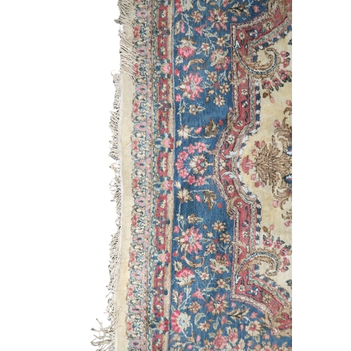 2183 - AN IVORY GROUND AUBUSSON STYLE RUG with multicoloured floral patterned ground within shaped blue flo... 