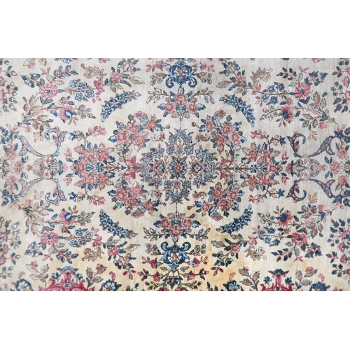 2183 - AN IVORY GROUND AUBUSSON STYLE RUG with multicoloured floral patterned ground within shaped blue flo... 