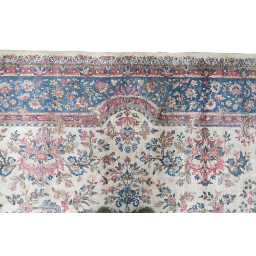 2183 - AN IVORY GROUND AUBUSSON STYLE RUG with multicoloured floral patterned ground within shaped blue flo... 