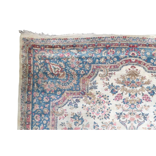 2183 - AN IVORY GROUND AUBUSSON STYLE RUG with multicoloured floral patterned ground within shaped blue flo... 