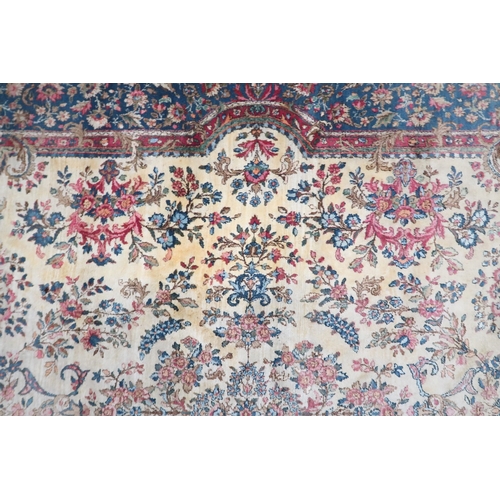 2183 - AN IVORY GROUND AUBUSSON STYLE RUG with multicoloured floral patterned ground within shaped blue flo... 