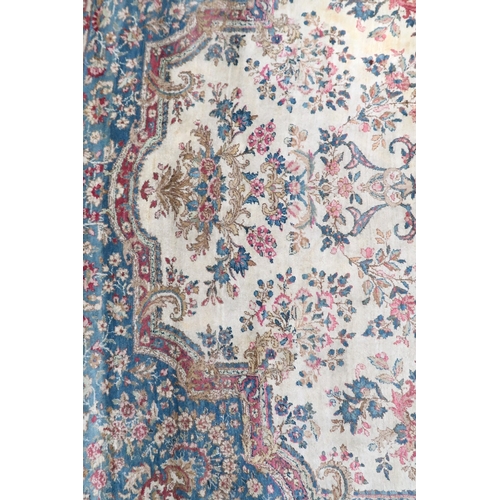 2183 - AN IVORY GROUND AUBUSSON STYLE RUG with multicoloured floral patterned ground within shaped blue flo... 