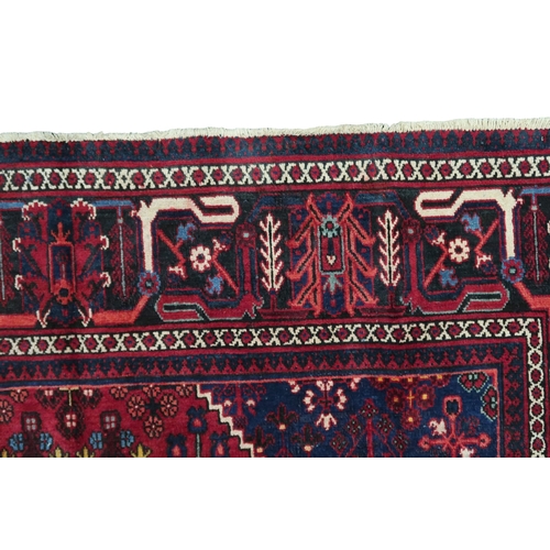 2184 - A DARK RED JOSHAGAN RUG with dark blue diamond medallion and matching spandrels on geometric pattern... 