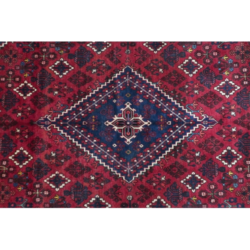 2184 - A DARK RED JOSHAGAN RUG with dark blue diamond medallion and matching spandrels on geometric pattern... 