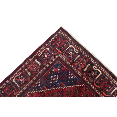 2184 - A DARK RED JOSHAGAN RUG with dark blue diamond medallion and matching spandrels on geometric pattern... 