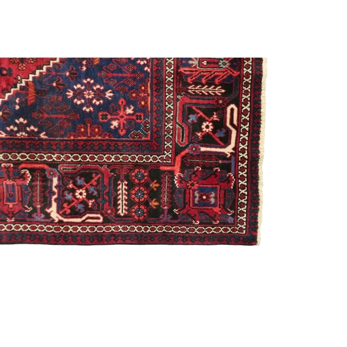 2184 - A DARK RED JOSHAGAN RUG with dark blue diamond medallion and matching spandrels on geometric pattern... 