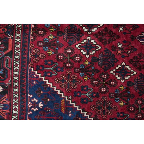 2184 - A DARK RED JOSHAGAN RUG with dark blue diamond medallion and matching spandrels on geometric pattern... 