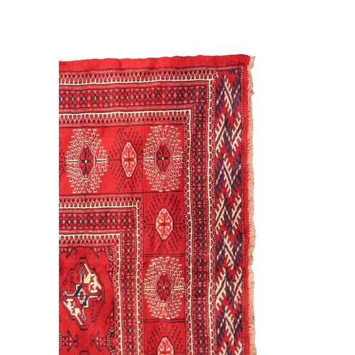 2185 - A RICH RED GROUND TURKMAN RUG with all-over lozenge design within geometric patterned border, 383cm ... 