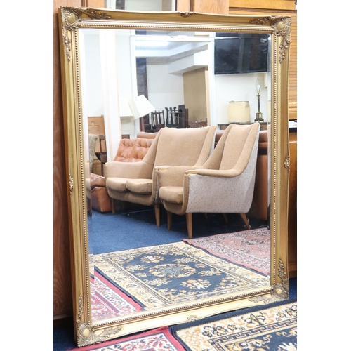 103 - A 20th century gilt framed bevelled glass wall mirror, 136cm high x 106cm wide