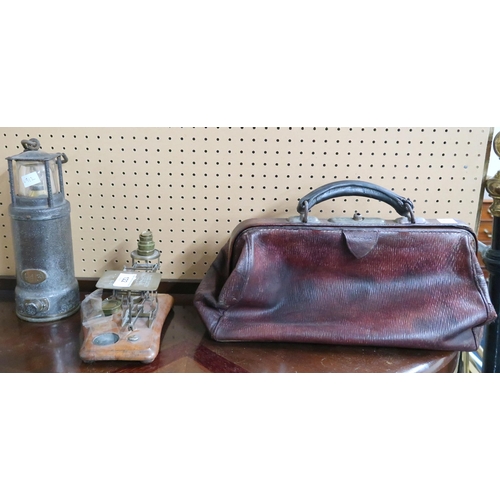 122 - A lot comprising a leather Gladstone style bag, Oldham patent lantern and small brass postal scale (... 