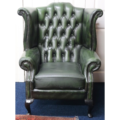 20 - A 20th century green leather upholstered buttoned wingback armchair on cabriole supports, 107cm high... 