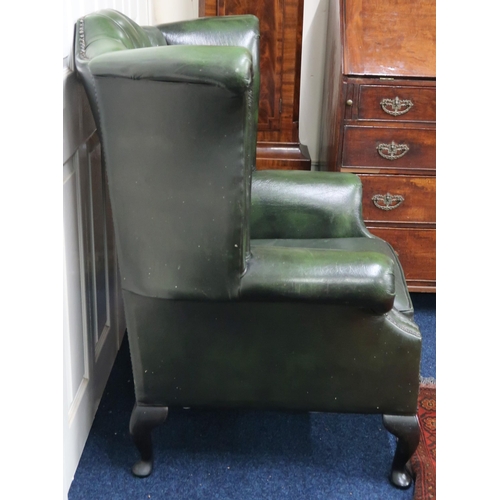 20 - A 20th century green leather upholstered buttoned wingback armchair on cabriole supports, 107cm high... 