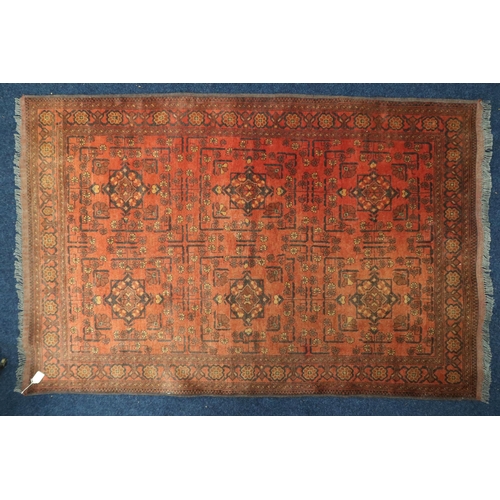 24 - A red ground Hamadan rug with multicoloured geometric patterned ground within multicoloured floral b... 