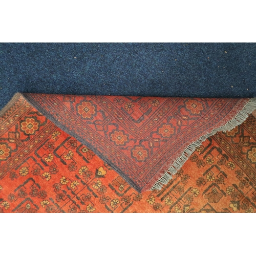 24 - A red ground Hamadan rug with multicoloured geometric patterned ground within multicoloured floral b... 