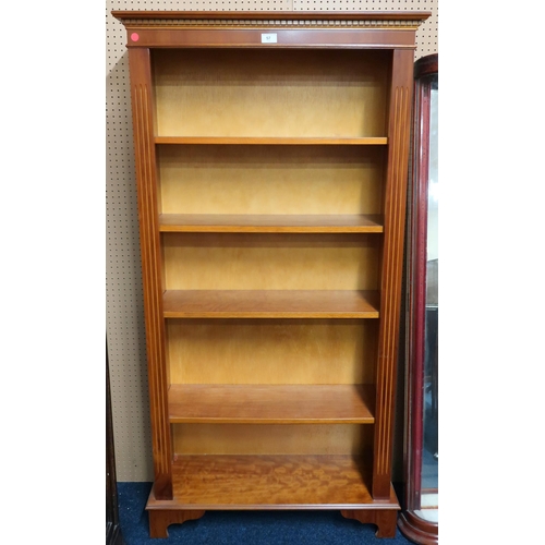 57 - A 20th century yew wood reproduction open bookcase with dentil cornice over four adjustable shelves ... 