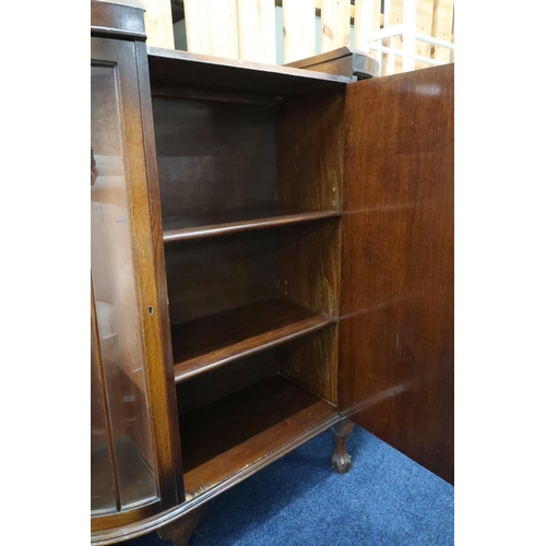 65 - A 20th century oak display cabinet with central cabinet door flanked by bowed glazed doors on shaped... 