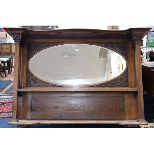 66 - A late Victorian oak Arts & Crafts overmantle mirror with oval bevelled glass pane over two shel... 