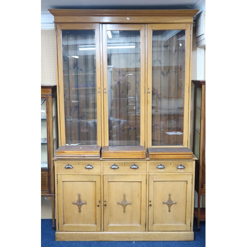 8 - A 19th century white oak glazed library bookcase with moulded cornice over three glazed doors on bas... 