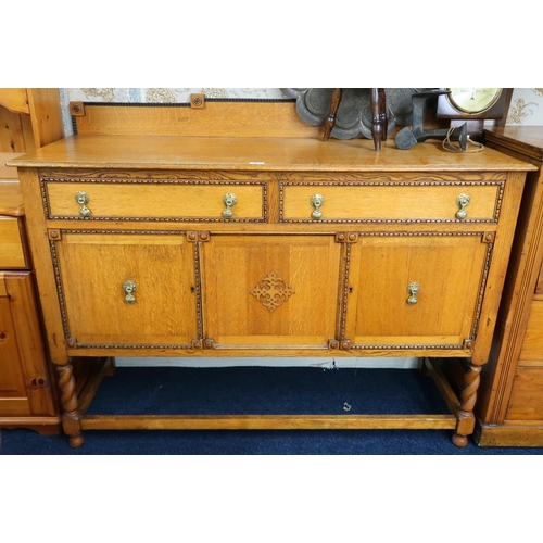 86 - An early 20th century oak sideboard with two drawers over pair of cabinet doors on barley twist supp... 