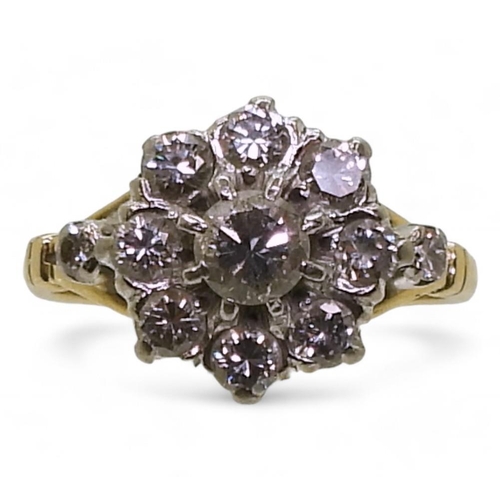 An 18ct and platinum mounted diamond flower ring, set with estimated approx 0.65cts of brilliant cut diamonds, finger size J1/2, weight 3.3gms