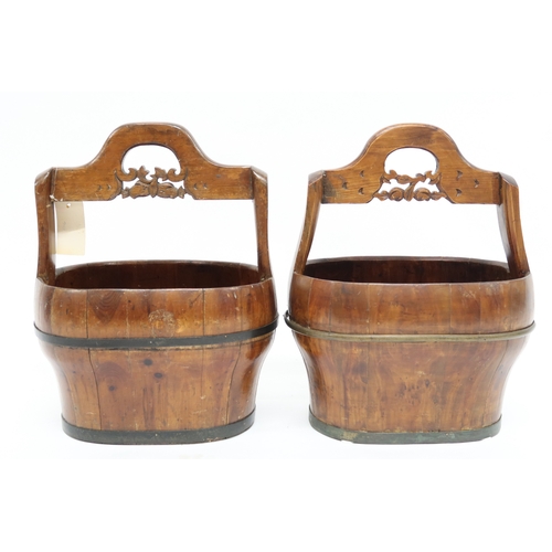 2021 - A PAIR OF 20TH CENTURY CHINESE HARDWOOD WATER CARRIERS with carved pierced carry handles over cooper... 