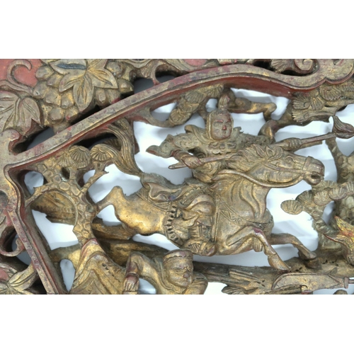 2024 - A 20TH CENTURY CHINESE GILTWOOD CARVED DECORATIVE WALL PANEL depicting Chinese warriors on horseback... 