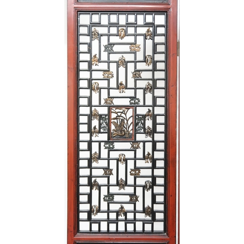 2029 - A 20TH CENTURY CHINESE RED AND BLACK LACQUERED FOUR FOLD ROOM DIVIDER each panel with carved pierced... 