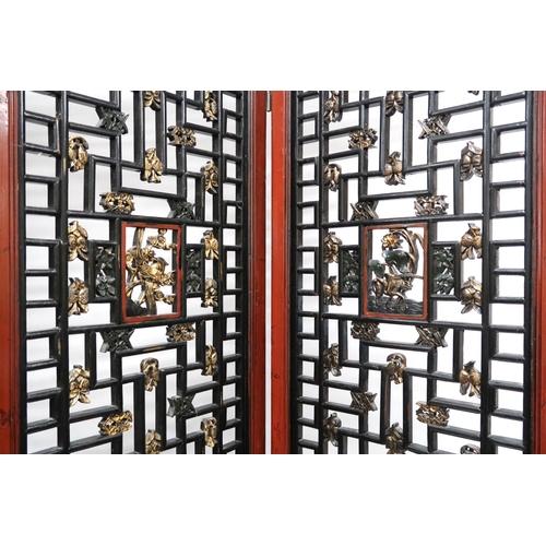 2029 - A 20TH CENTURY CHINESE RED AND BLACK LACQUERED FOUR FOLD ROOM DIVIDER each panel with carved pierced... 