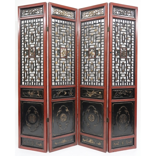 2029 - A 20TH CENTURY CHINESE RED AND BLACK LACQUERED FOUR FOLD ROOM DIVIDER each panel with carved pierced... 