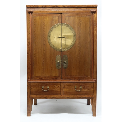 2026 - A 20TH CENTURY CHINESE ELM WEDDING CABINET with pair of doors mounted with brass plaque depicting an... 