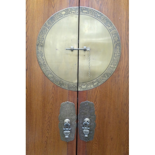 2026 - A 20TH CENTURY CHINESE ELM WEDDING CABINET with pair of doors mounted with brass plaque depicting an... 