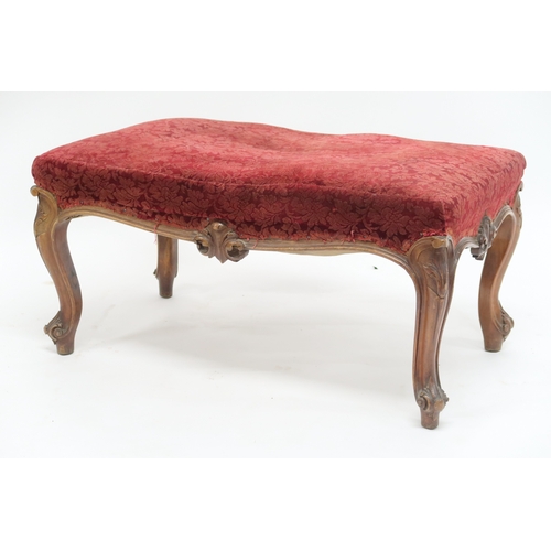 2033 - A LARGE 19TH CENTURY WALNUT FRAMED FOOTSTOOL with red velvet Damask upholstery on carved serpentine ... 