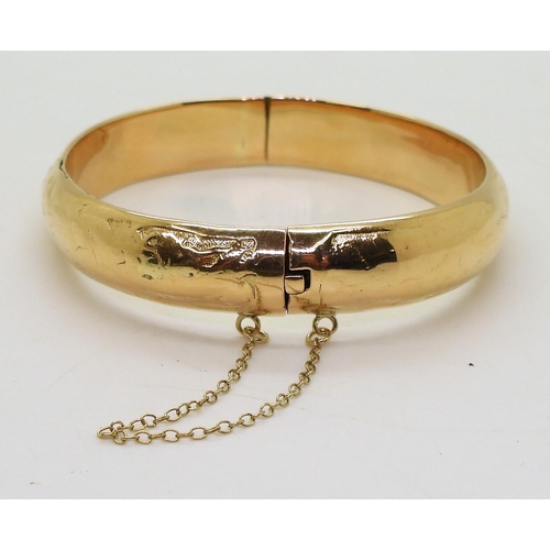 727 - A yellow metal heavy bangle, stamped but unreadable, inner diameter 6cm, weight 28.7gms