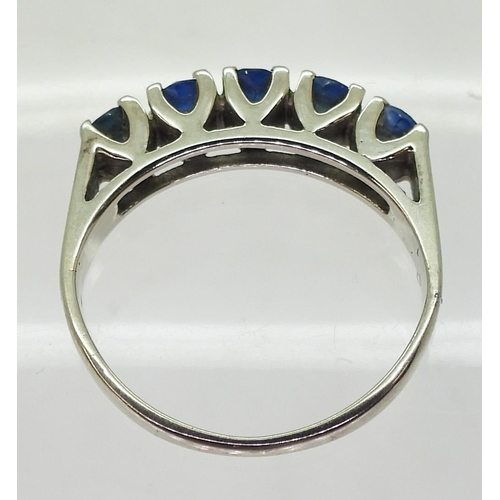 788 - A white metal ring stamped 18K, set with five sapphires, size K, weight 3.2gms