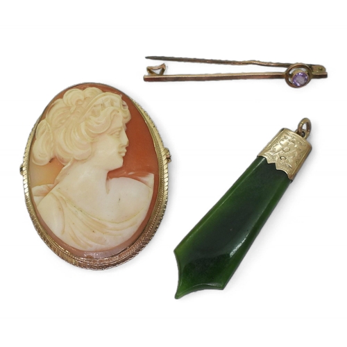 832B - A 9ct gold mounted cameo brooch, New Zealand hardstone pendant and a 9ct amethyst brooch, weight all... 