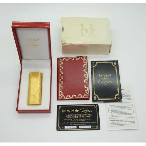 844 - A Gold plated lighter, marked 'Le Must de Cartier', with original box, paperwork and guarantee, toge... 