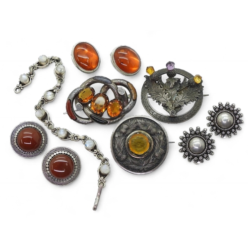 860 - A collection of Scottish themed brooches, to include a white metal thistle brooch, agate inlaid broo... 