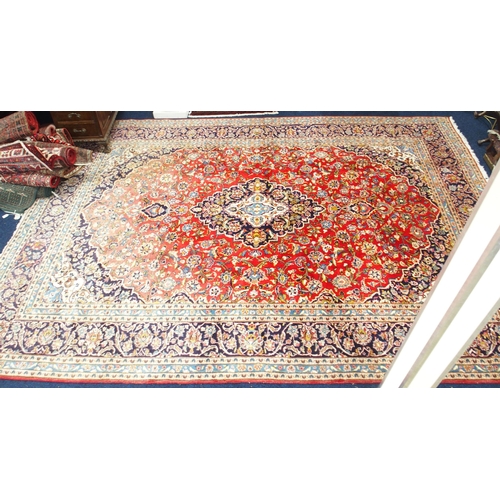 1 - A red ground Keshan rug with dark blue and cream central medallion and matching spandrels on floral ... 