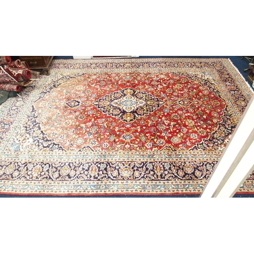 1 - A red ground Keshan rug with dark blue and cream central medallion and matching spandrels on floral ... 