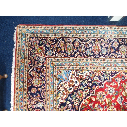 1 - A red ground Keshan rug with dark blue and cream central medallion and matching spandrels on floral ... 