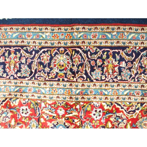 1 - A red ground Keshan rug with dark blue and cream central medallion and matching spandrels on floral ... 