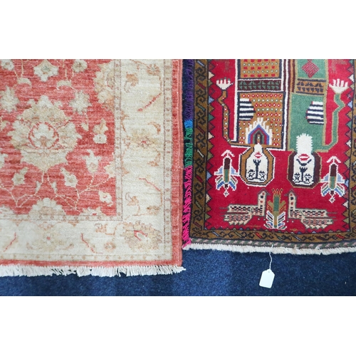 21 - A lot comprising a red ground Tribal style rug with figural designed ground within multicoloured fri... 