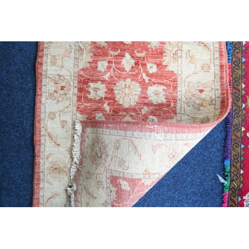 21 - A lot comprising a red ground Tribal style rug with figural designed ground within multicoloured fri... 