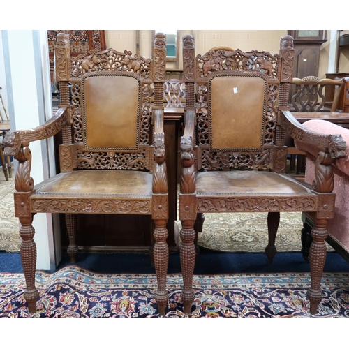 28 - A pair of Anglo Indian style hardwood armchairs with extensively carved and pierced backrests with l... 