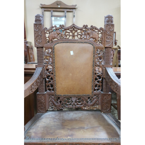 28 - A pair of Anglo Indian style hardwood armchairs with extensively carved and pierced backrests with l... 