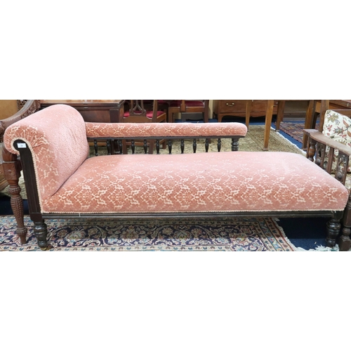 29 - A Victorian mahogany framed chaise longue with pink Damask upholstery on turned supports terminating... 