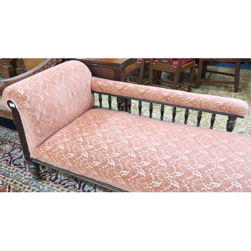 29 - A Victorian mahogany framed chaise longue with pink Damask upholstery on turned supports terminating... 