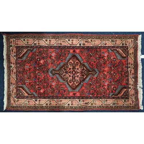 32 - A red ground Hamadan rug with pink diamond shape central medallion and matching spandrels on geometr... 