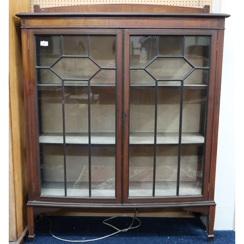 36 - An early 20th century bow front astragal glazed two door display cabinet on square tapering supports... 