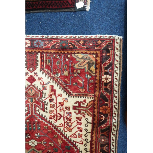 38 - A cream ground Hamadan rug with red central medallion and matching spandrels on geometric patterned ... 